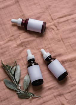 Elegant dropper bottles with neutral labels on fabric, ideal for skincare branding.