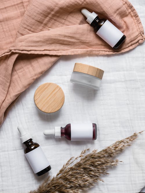 Free Cosmetic Containers on White Textile Stock Photo
