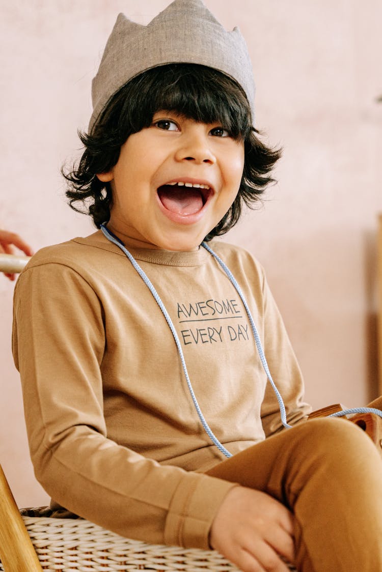 A Happy Kid Wearing Brown Long Sleeves Shirt 