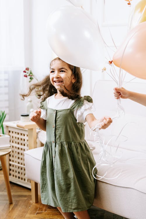 Free Happy Girl holding a Bouquet of Balloons  Stock Photo