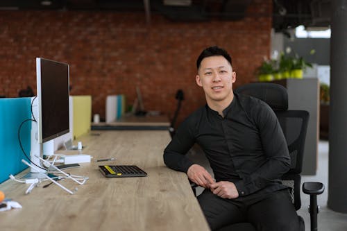 Man in Black Long Sleeve Shirt Sitting on a Black Armchair