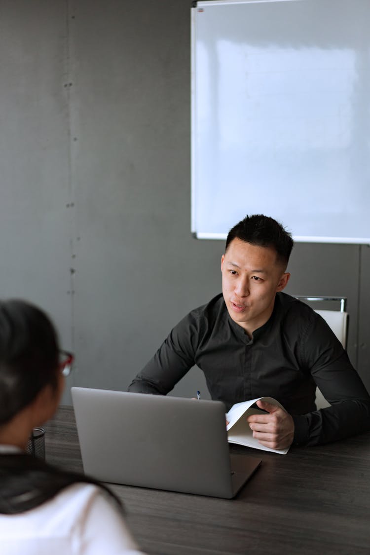 Man In Black Long Sleeve Shirt Talking To Another Person