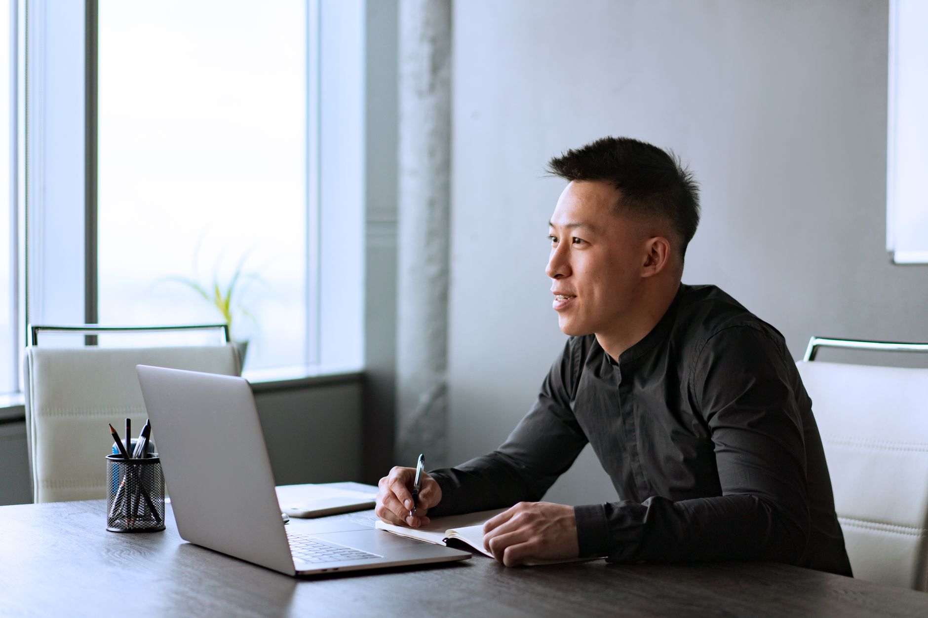 A professional looking out an office window, reflecting on their career path.
