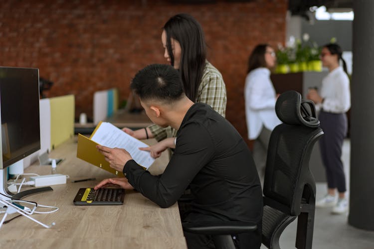 Man In Black Long Sleeve Shirt Sitting On Black Office Rolling Chair