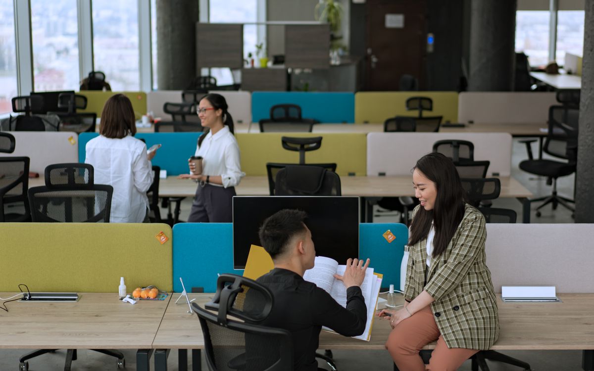 Dynamic office environment with team members engaged in collaboration and discussion.