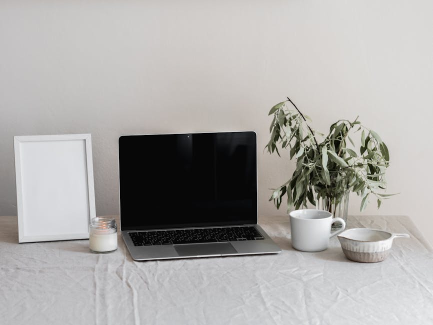 A Blank Picture Frame Near a Laptop