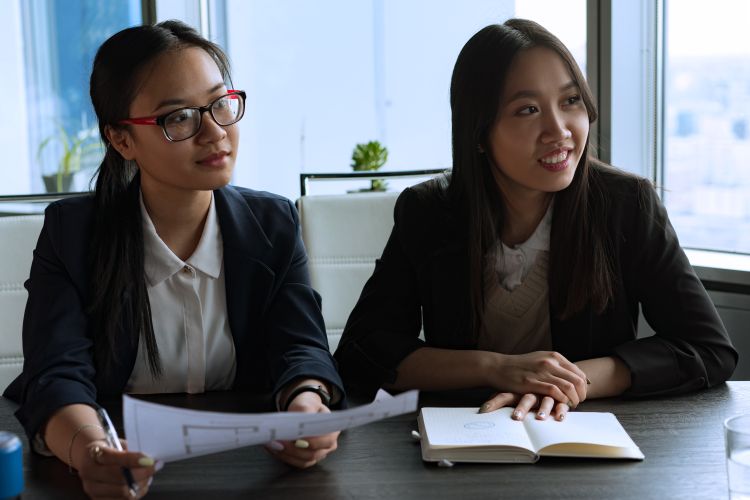 Hai doanh nhân châu Á thảo luận trong cuộc họp kinh doanh