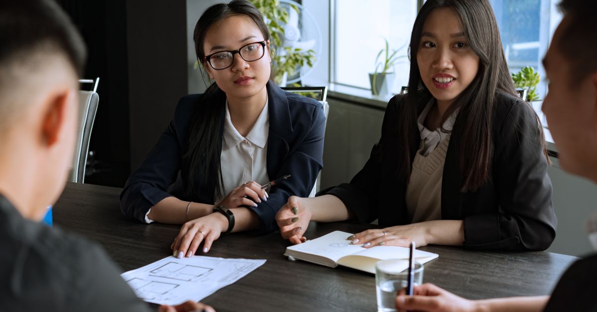Professional business meeting with a diverse group discussing strategies in an office setting.