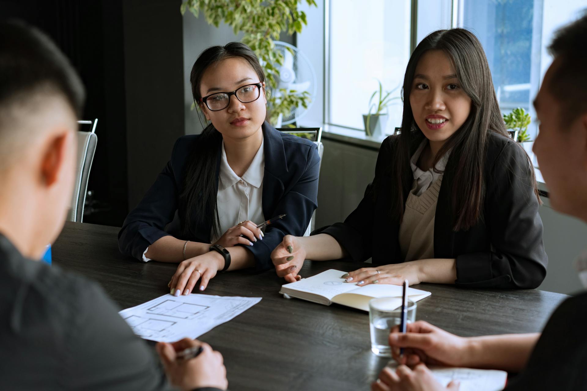 Professional business meeting with a diverse group discussing strategies in an office setting.