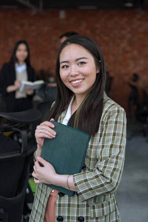 Free Cheerful businesswoman with a tablet in a modern office setting. Stock Photo