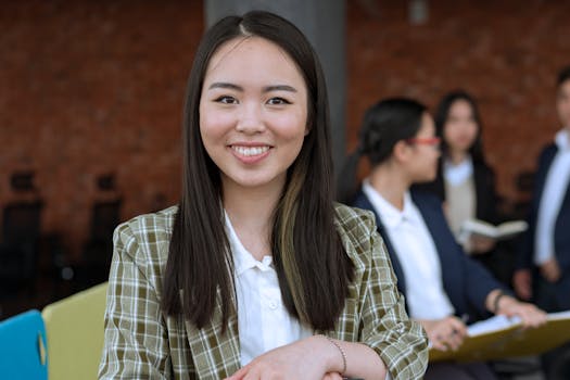Smiling Asian woman in office, showcasing a professional work environment.