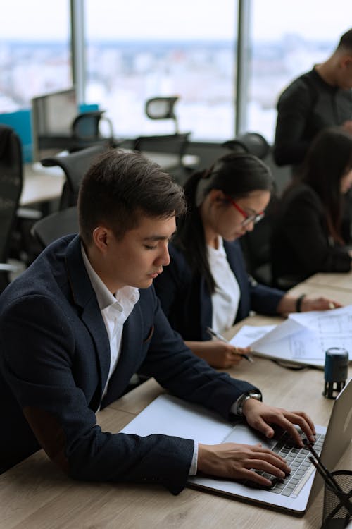 Man in Black Suit Jacket Using a Laptop