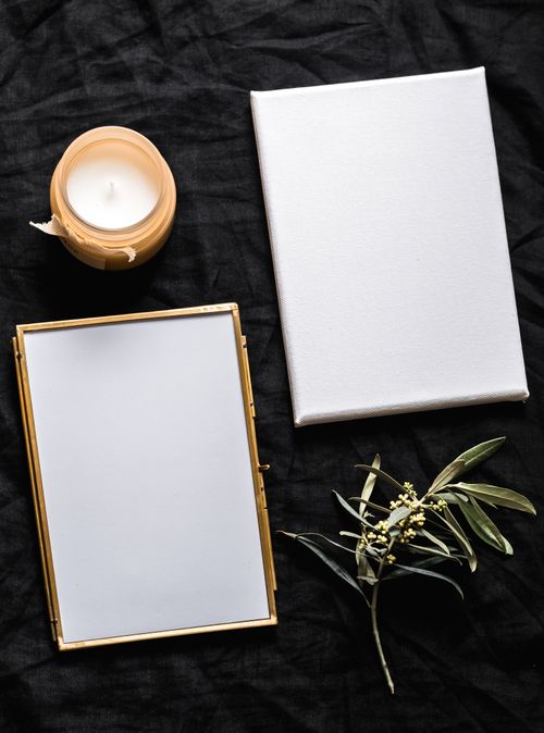 Free Sophisticated flat lay featuring a candle, blank paper, and floral accents for elegant presentations. Stock Photo