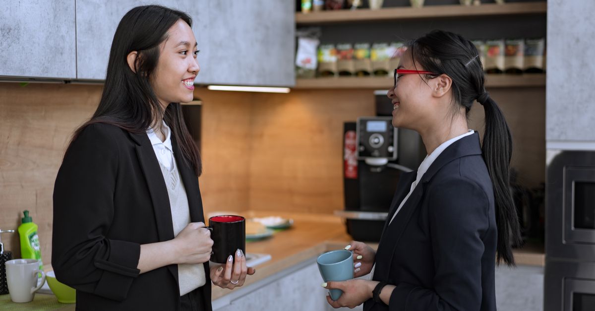 diverse coworkers chatting in a modern office kitchen