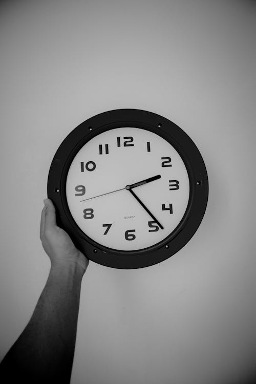 Free Person Holding a Wall Clock Stock Photo