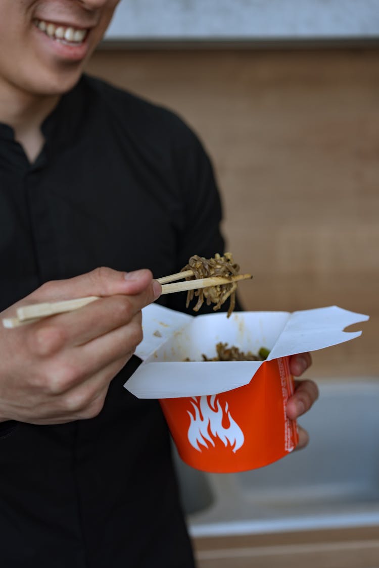 Man Eating Chinese Food On Takeout Box