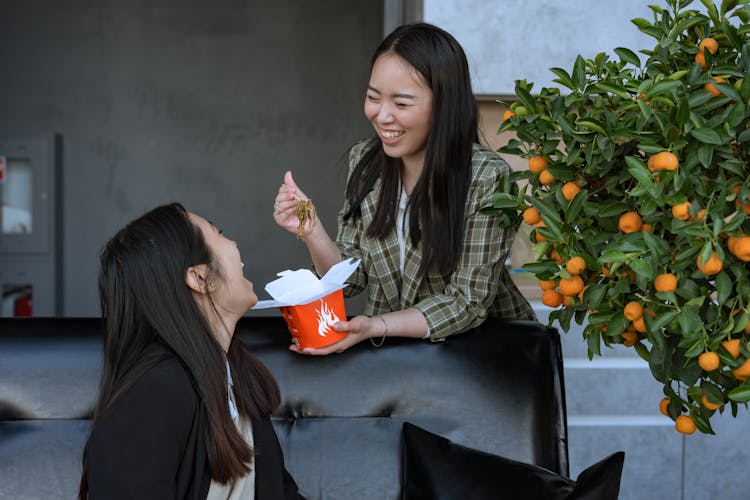 Two Women Giggling While Eating