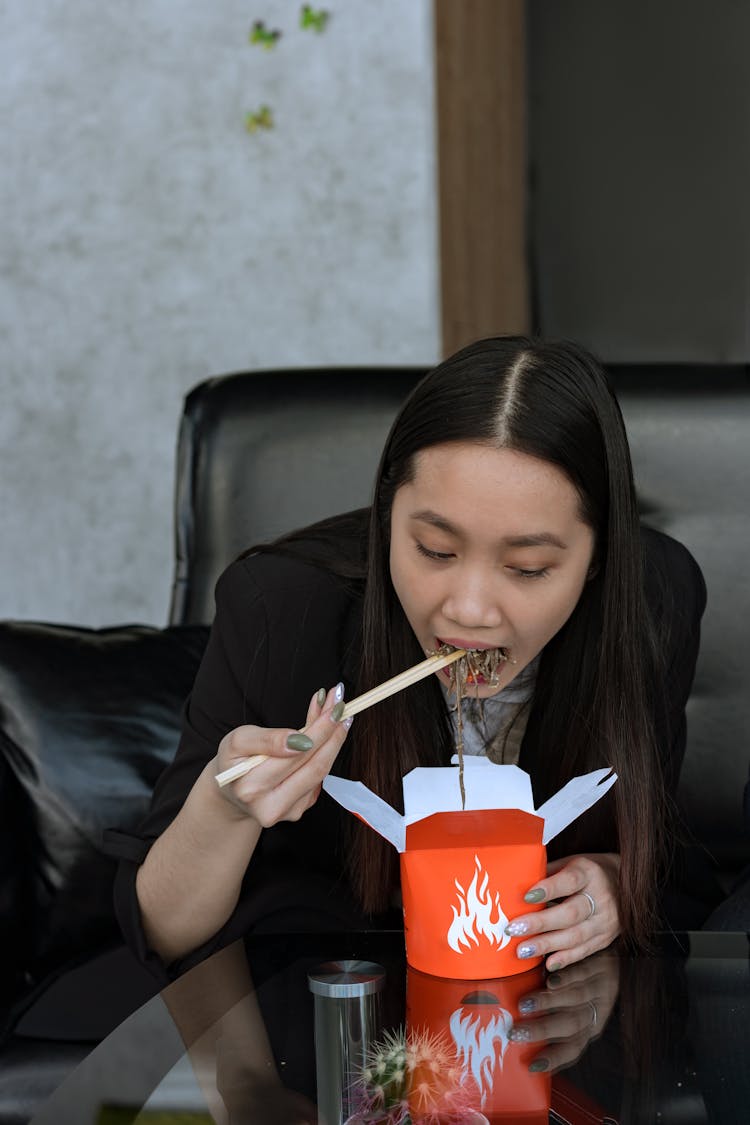 Woman Eating Noodles Using Chopsticks