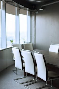 Spacious conference room with sleek furniture and large windows providing natural light.