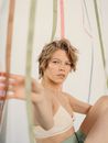A Woman in White Bralette Touching Ribbons
