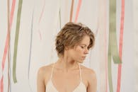 一位短发、闭着眼睛的女人的美丽肖像，背景是彩色丝带