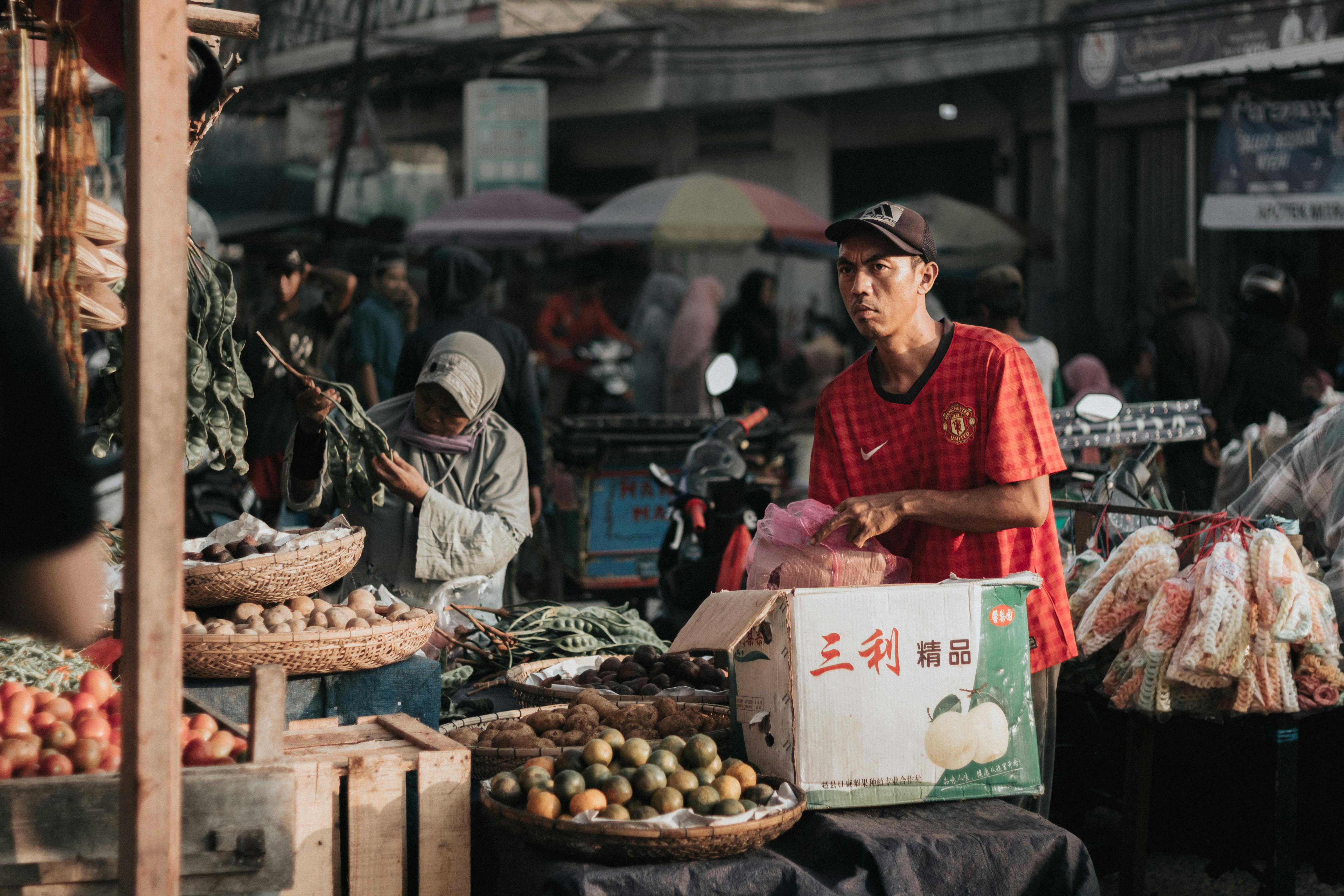 A man sells fruits and vegetables at an outdoor market.