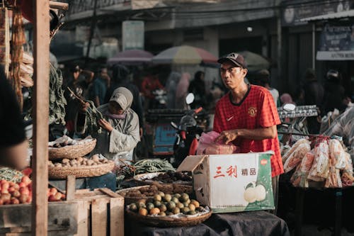 Man Standing in Front of a Fruit Stall 