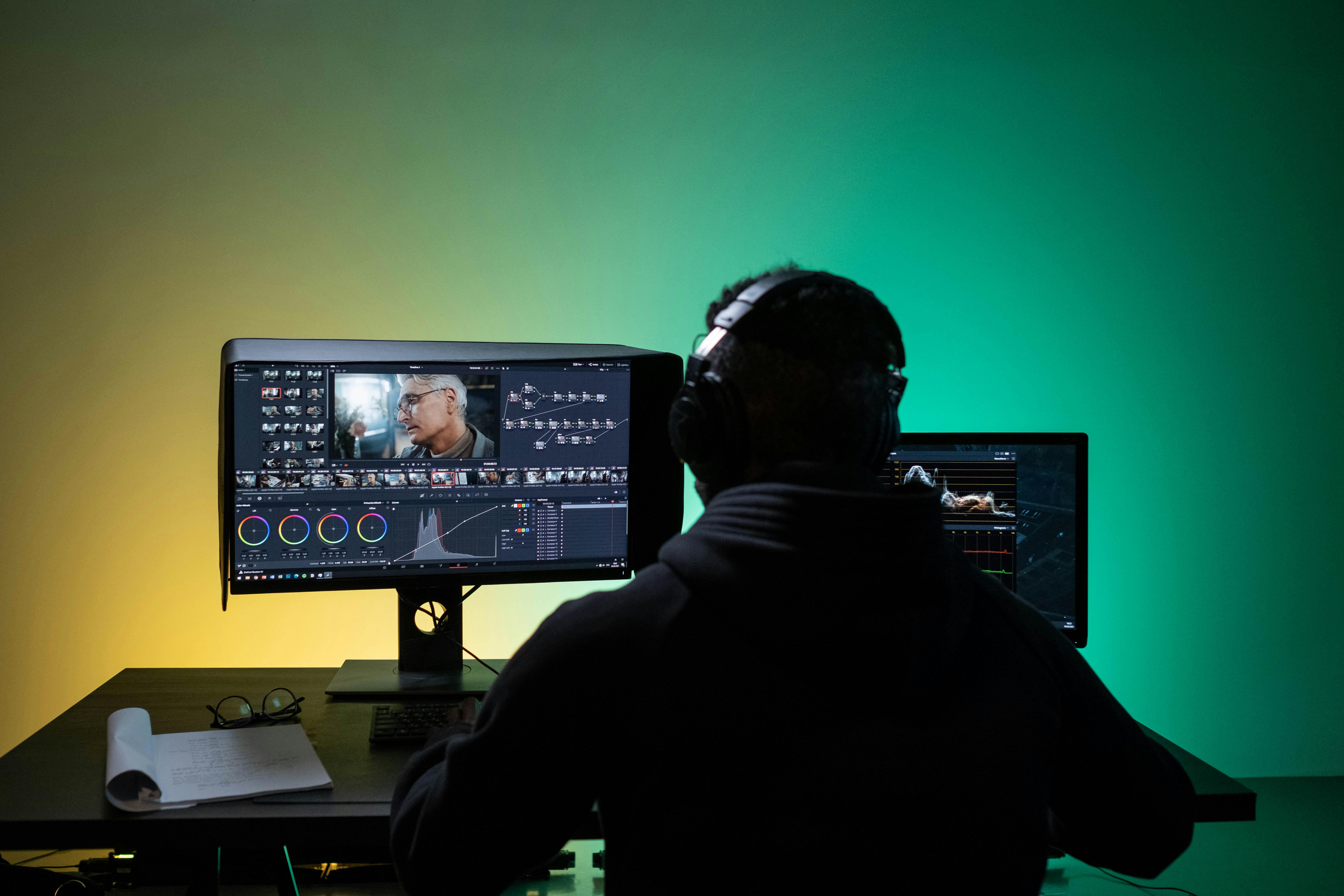 a man sitting on front of the computer while editing video