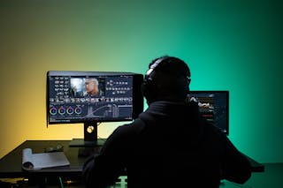 A Man Sitting on Front of the Computer while Editing Video