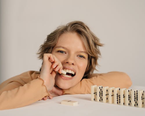 Woman Biting a Piece of Domino