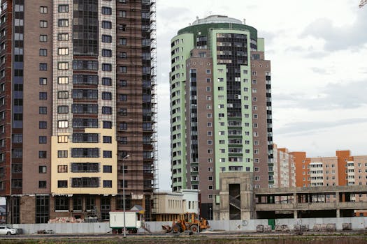 Urban skyline featuring contemporary high-rise buildings and construction site in city setting.