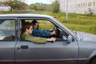 Man in Blue Jacket Lying on Black Car