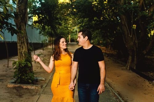 Free Couple walking hand in hand in a sunlit park, smiling and enjoying each other's company. Stock Photo