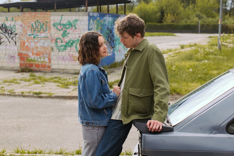 Couple In Denim Jackets Beside A Car