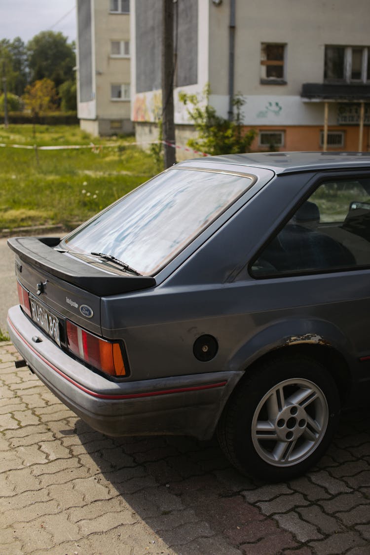 An Old Car Parked On Paved Road