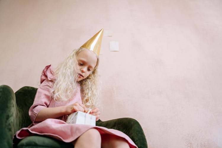 
A Birthday Girl Opening A Gift