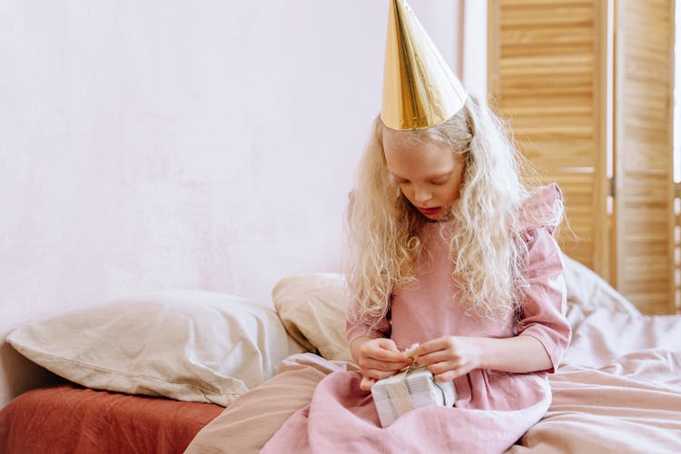 
A Birthday Girl Opening A Gift