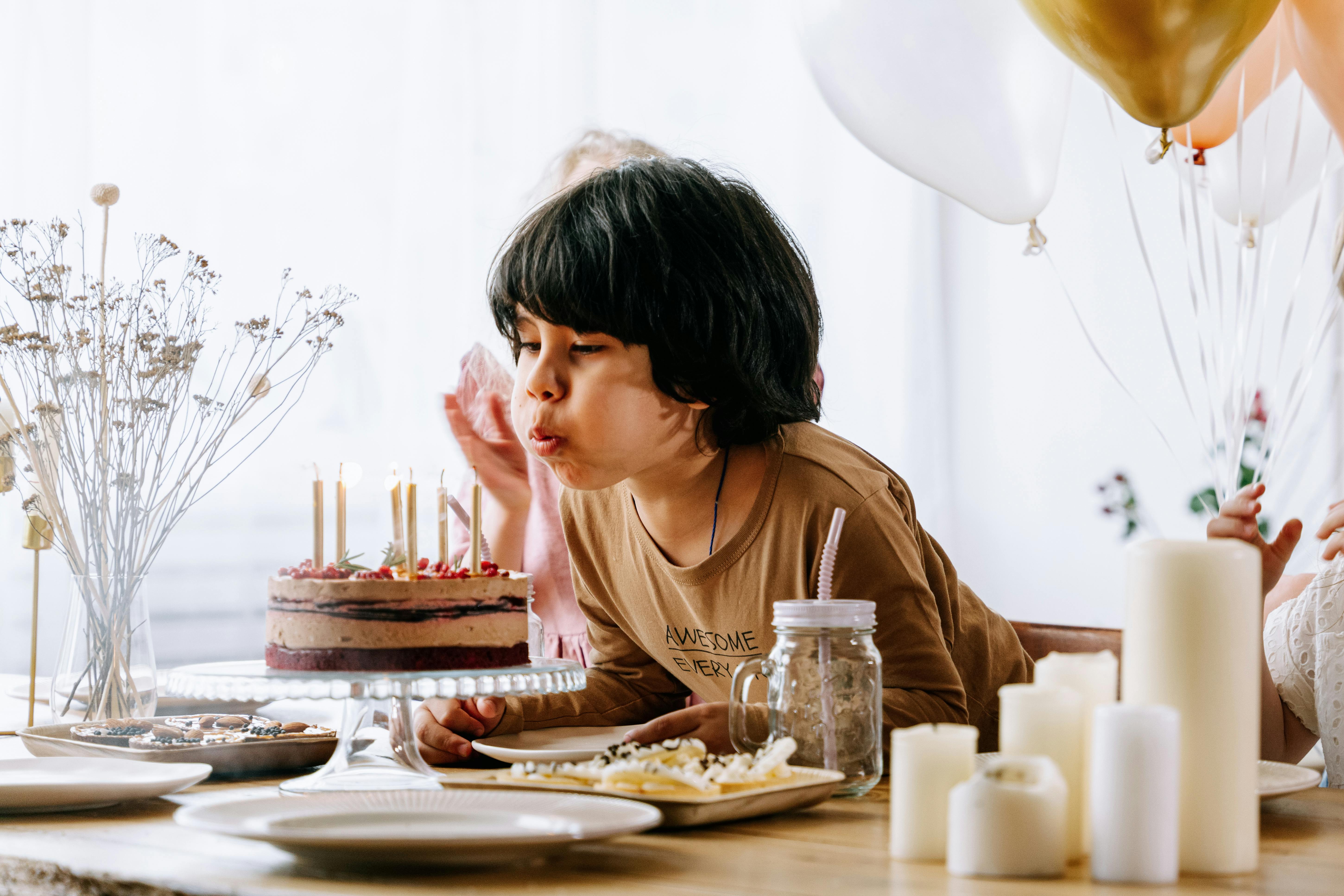 boy blowing candles on a cake