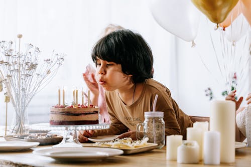 Free Boy Blowing Candles on a Cake Stock Photo