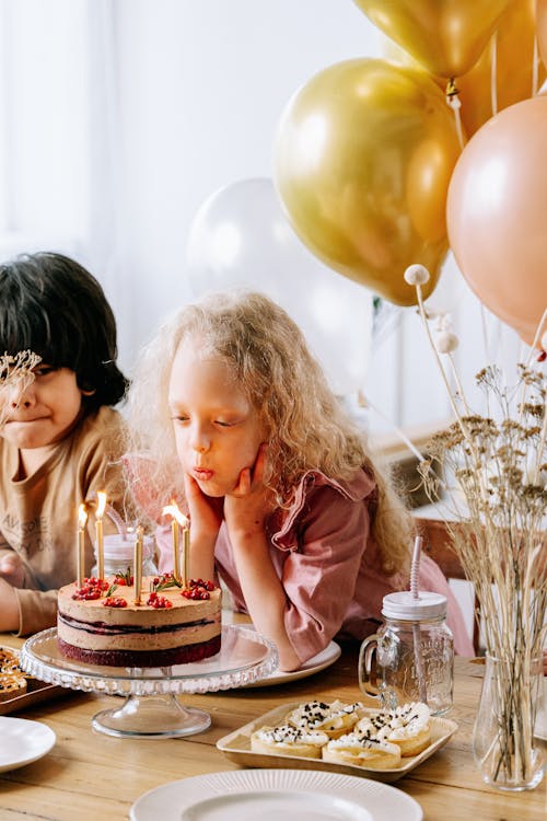 Girl Blowing Candles on a Cake