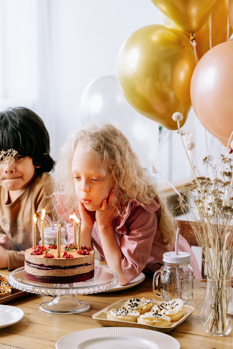 Girl Blowing Candles On A Cake