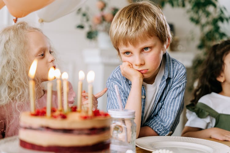 Sad Boy Looking At A Cake