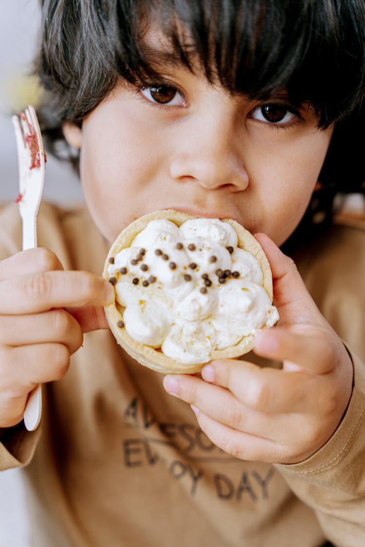 
A Boy Eating A Pastry