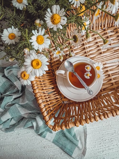 Free Teacup with Saucer on a Woven Tray Near White Flowers Stock Photo