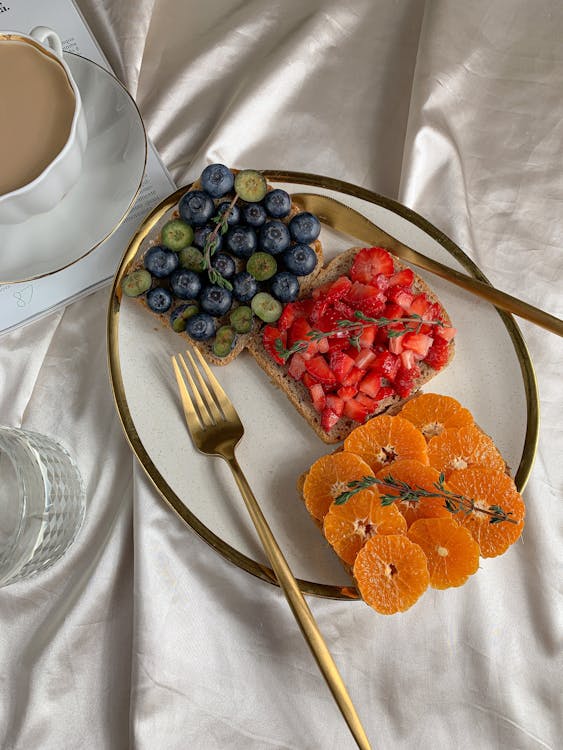 A Fresh Fruits on Top of the Bread on a Ceramic Plate
