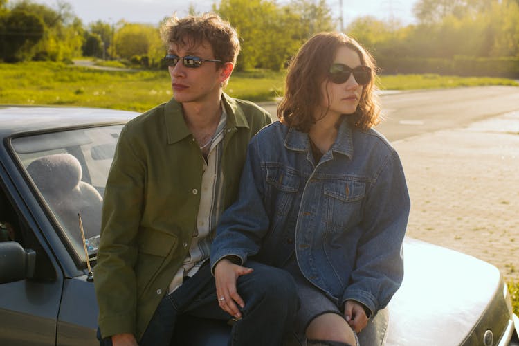 Couple Wearing Sunglasses Sitting At The Car