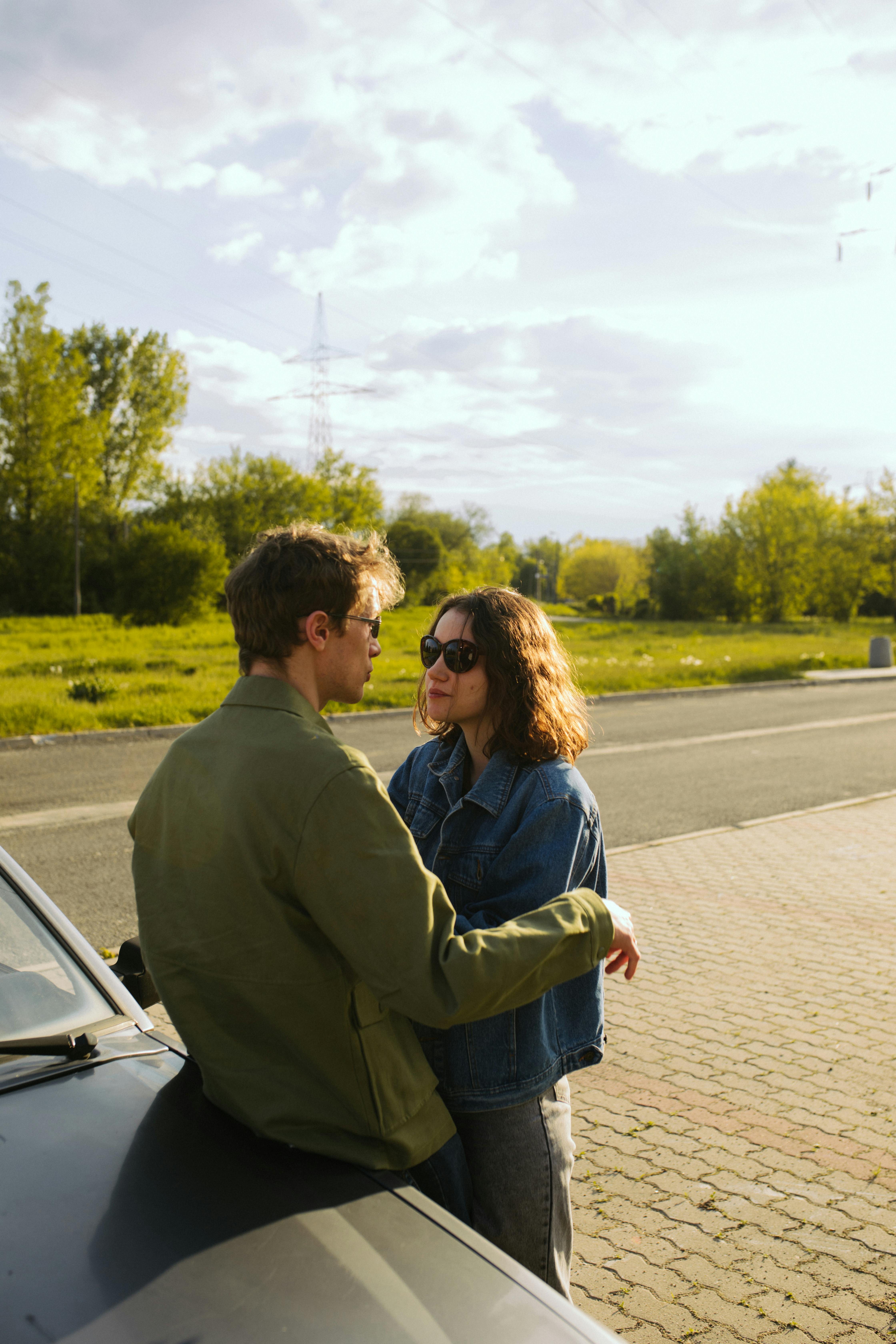 man and woman standing beside car
