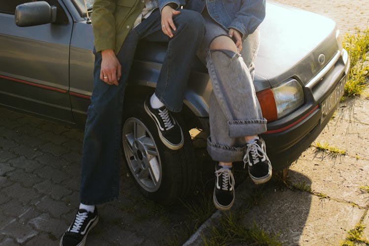 Couple Sitting On A Car Hood