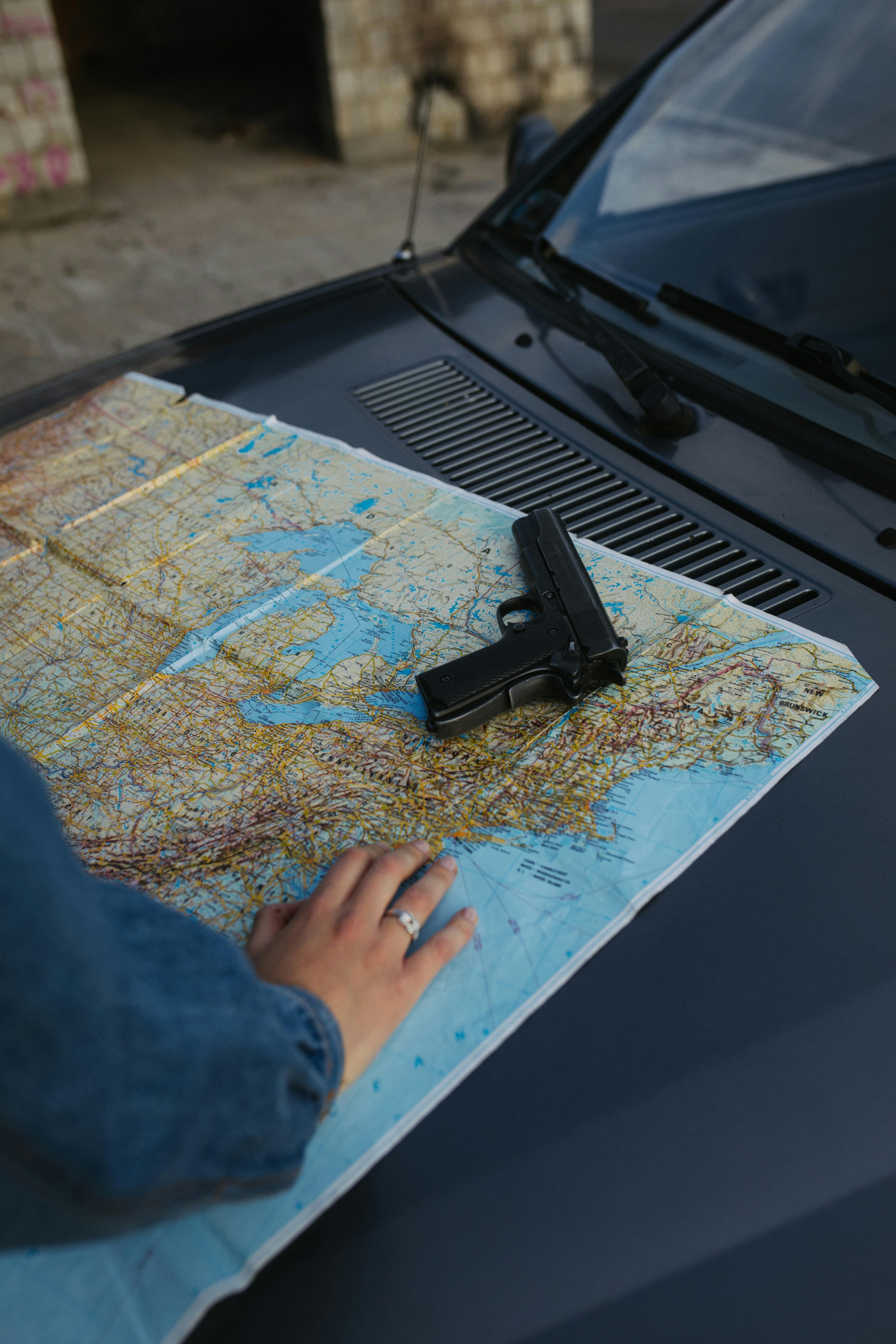 A Handgun and a Map on a Car Hood · Free Stock Photo