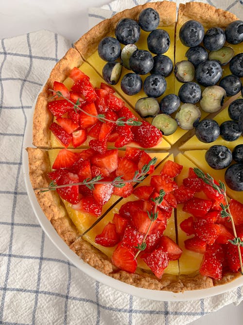 A Sliced Cake with Strawberries and Blueberries on Top